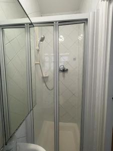 eine Dusche mit Glastür neben einem WC in der Unterkunft New Studio on Golders Green RD in London