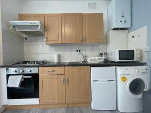 een keuken met een fornuis, een wastafel en een vaatwasser bij New Studio on Golders Green RD in Londen