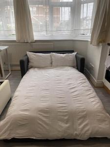 a large white bed in a room with windows at New Studio on Golders Green RD in London
