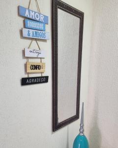 a mirror hanging on a wall with some signs at Apartamento Dei Fiori in Guaramiranga