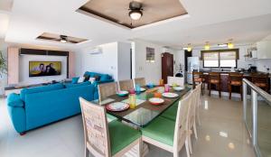 a dining room and living room with a blue couch and a table at Family Vacations apartment Ocean View in Cancún