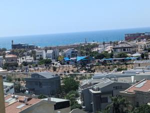 a city with houses and the ocean in the background at Luxury Breathtaking Seafront Penthouse Duplex in Rishon LeẔiyyon