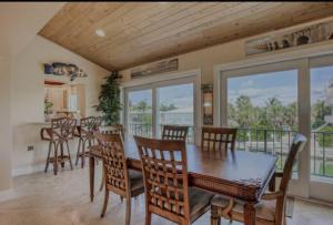 a dining room with a table and chairs and a balcony at Salty Slumber Relaxing 2 bedroom 2 bath Get Away in the Lower Keys in Summerland Key