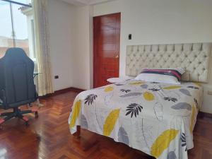 een slaapkamer met een bed, een bureau en een stoel bij Valentina House in Tacna