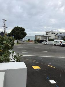 an empty street with cars parked on the road at Beachside studio in New Plymouth