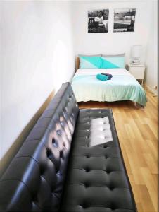 a bedroom with a bed and a black leather couch at ¶Pet Friendly Cosy Quite Room+TV+Sofa in Glenfield