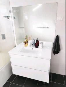 a white bathroom with a white sink and a mirror at ¶Pet Friendly Cosy Quite Room+TV+Sofa in Glenfield