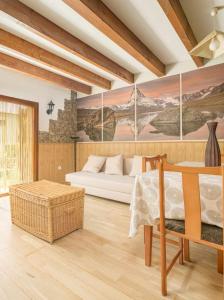 - un salon avec un lit et un tableau mural dans l'établissement Casa los Altos de Santiago, à Villanúa