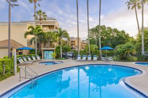 uma piscina num resort com cadeiras e guarda-sóis em Marriott's Imperial Palms Villas em Orlando