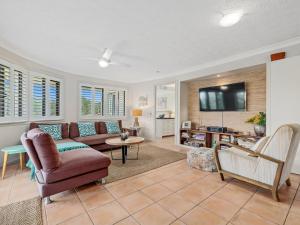 a living room with a couch and a tv at Shoreline 3 Beachfront Apartment in Hastings Point