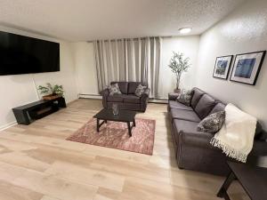 - un salon avec un canapé et une télévision dans l'établissement Stay Anchorage! Furnished Two Bedroom Apartments With High Speed WiFi, à Anchorage