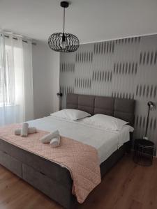a bedroom with a large bed with two towels on it at Apartments by the sea Baska Voda, Makarska - 12209 in Baška Voda