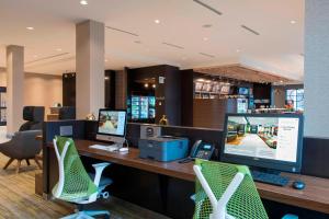 un ufficio con una scrivania con due computer e sedie di Courtyard by Marriott Holland Downtown a Holland