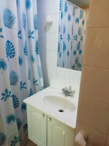 a bathroom with a sink and a shower curtain at Condominio Ilimay Las Cruces in Las Cruces