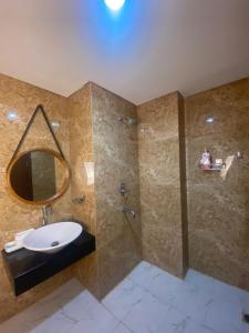 a bathroom with a sink and a shower with a mirror at Comfy Apartment Grand Sungkon Lagoon in Dukuhpakis