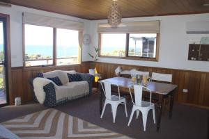 Sandy Toes في Greens Beach: غرفة معيشة مع طاولة وأريكة