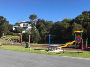 a park with a playground with a slide and swings at Sandy Toes in Greens Beach