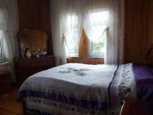 een slaapkamer met een bed en een raam met gordijnen bij Sakin Köy Evi Kaçamağı in Arsin