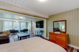 a room with a bed and a dresser and a mirror at Mill Pond Suite in East Boothbay