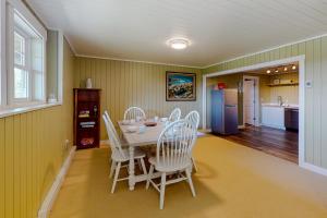 uma sala de jantar com uma mesa e cadeiras brancas em Mill Pond Suite em East Boothbay