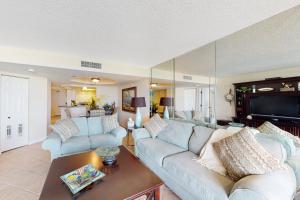 a living room with two couches and a table at Lighthouse Towers #206 in Clearwater Beach