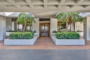 a building with a lobby with palm trees and a door at Lighthouse Towers #206 in Clearwater Beach