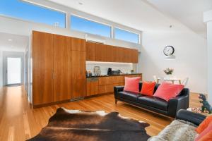 - un salon avec un canapé noir et des oreillers orange dans l'établissement Coral Villa, à Maleny