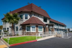 薩克拉門托的住宿－Quality Inn Elk Grove-Sacramento，前面有棕榈树的房子