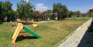 a playground with a slide and swings at Athina Studios in Argasi