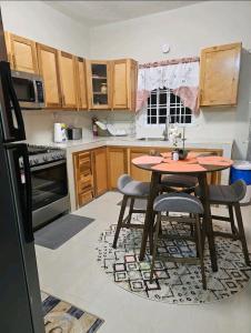 a kitchen with a table and chairs in it at S.G Apartment Complex. in Linstead