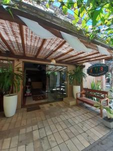 a patio with a wooden pergola and some plants at Pousada Bar Café Algas Marinhas in Praia do Forte