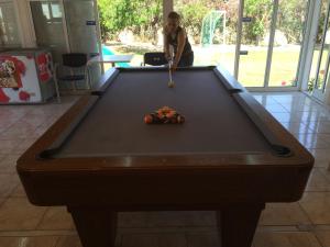 a woman playing a game of pool on a table at Athina Studios in Argasi