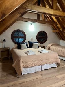 ein Schlafzimmer mit zwei Betten in einem Zimmer mit Holzdecken in der Unterkunft La casita de LOS CERROS DE SMA in San Martín de los Andes
