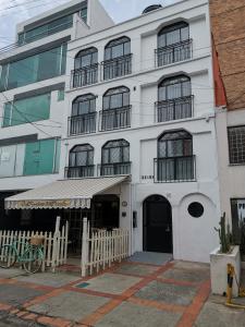 Biały budynek z płotem przed nim w obiekcie 86 suites w mieście Bogota