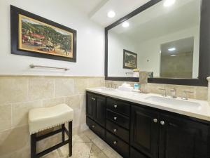 a bathroom with a sink and a mirror and a stool at Catalina Courtyard Suites in Avalon