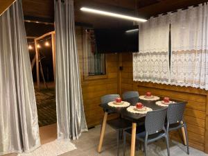 uma mesa de jantar e cadeiras num quarto com cortinas em Pousada Chalé Flor de Hibisco 2 em Penha
