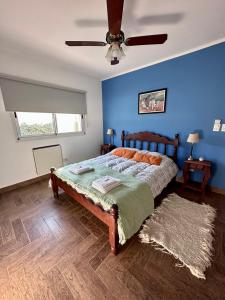 um quarto com uma cama com uma parede azul em Casa Valle del colibrí em Cañada La Negra