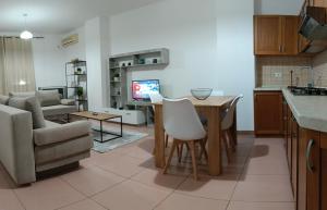 Una cocina y una sala de estar con una mesa y un sofá. en CALM Blue Sea, en Durrës