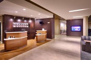 a wine tasting room with a bar and a tv at Courtyard by Marriott Phoenix Mesa Gateway Airport in Mesa