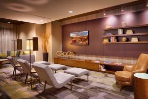 梅薩的住宿－梅薩門戶機場鳳凰城萬怡酒店，一间设有椅子的等候室和一个美发沙龙