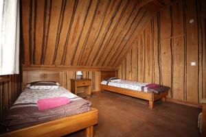 a bedroom with two beds in a wooden room at Recreation Center Brūveri in Sigulda