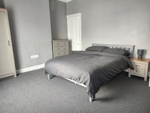 a bedroom with a large bed and a dresser at Leicester Street in Burton upon Trent
