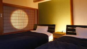 a room with two beds and a window at Okukinosaki Seaside Hotel in Toyooka