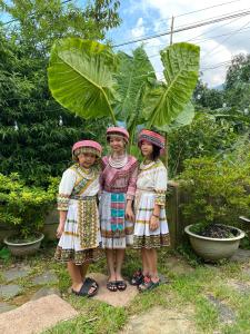 three girls in traditional dress posing for a picture at Eco Joville House - Sapa Homestay in Sa Pa