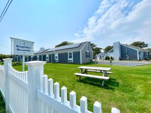 a picnic table in a yard next to a fence at Kingfisher Oceanside in Dennis Port