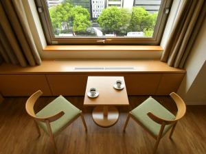 two chairs and a table in front of a window at Sapporo View Hotel Odori Park in Sapporo