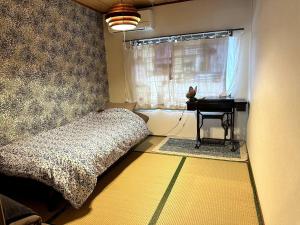a bedroom with a bed and a window with a table at KASUMI-an Sora in Shimo-tatsuda