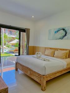 a bedroom with a large bed with a large window at Lemon Guest House in Canggu