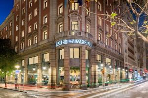 a large building on a city street at night at Le Meridien Barcelona in Barcelona