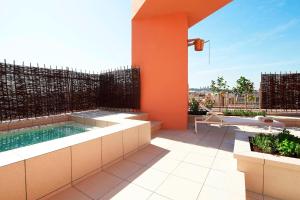 a patio with a hot tub on top of a building at Le Meridien Barcelona in Barcelona